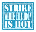 STRIKE WHILE THE IRON IS HOT, text written on blue stamp sign Royalty Free Stock Photo