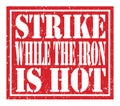 STRIKE WHILE THE IRON IS HOT, text written on red stamp sign Royalty Free Stock Photo