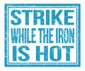 STRIKE WHILE THE IRON IS HOT, text on blue grungy stamp sign Royalty Free Stock Photo