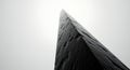 Black rock monolith reaching into the white sky Royalty Free Stock Photo
