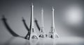 Three eiffel tower miniatures showcased in artistic black and white lighting Royalty Free Stock Photo