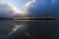 Reflection of threatening rain clouds on the water pooled surface of Red Wharf Bay, Anglesey