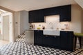 Striking cottage kitchen with black cabinetry and tiled splashback