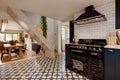 Striking cottage kitchen with dark coloured cabinetry and tiled splashback