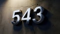 Chrome 3D Numbers 543 on a Textured Concrete Wall with Dramatic Lighting Royalty Free Stock Photo