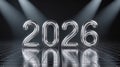 Silver 2026 numbers on a reflective grid floor with spotlights. Royalty Free Stock Photo