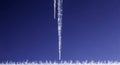 Sparkling icicle hangs against a deep blue sky Royalty Free Stock Photo