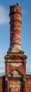 Extra-tall photograph of a weathered old brick chimney