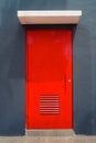 Striking Red Door against Dark Gray Walls. Portrait of a House Entryway Royalty Free Stock Photo