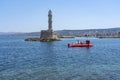 The striking semisubmarine sails past the old lighthouse into the Old harbor of Chania, Crete, Greece Royalty Free Stock Photo