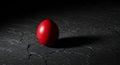 A dramatic red egg stands out on dark cracked stone Royalty Free Stock Photo