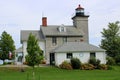 Large stone structure surrounded by lush landscaped gardens, Sodus Point Lighthouse, New York, summer, 2022