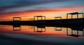 Striking Sunset Silhouettes of Gazebos Reflected in Calm Water reflection Royalty Free Stock Photo