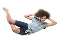 Striking an unusual pose. Young african american woman smiling while seated askew on a white background.