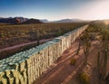 Conceptual representation of a border wall made of money in a desert landscape during sunset. Generative AI Royalty Free Stock Photo