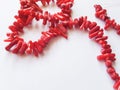 A string of beads from pieces of coral on a white background