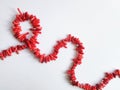 A string of beads from pieces of red coral on a white background