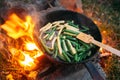 String beans in a pan. Cooking vegetables on an open fire. Food on a camping trip.