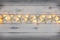 A string of golden star christmas lights, on a destressed woodern background Royalty Free Stock Photo