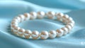 String of large white pearls on light blue satin fabric Royalty Free Stock Photo
