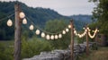 String Lights Hanging On Wooden Posts In A Scenic Outdoor Setting. Rustic Charm And Ambient Lighting For Outdoor Events Royalty Free Stock Photo