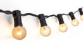 String of lit incandescent bulbs against a light wall
