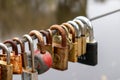 A string of many keys attached to a metal rope with a brown river water background