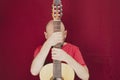 String musical instrument. Mature charismatic male guitarist. guy with beard holds guitar. bearded man in a red shirt