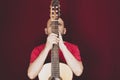 String musical instrument. Mature charismatic male guitarist. guy with beard holds guitar. bearded man in a red shirt