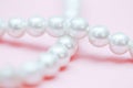 String of pearls delicate pink color, in soft focus, with highlights Royalty Free Stock Photo