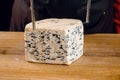 String for slicing blue cheese. Mix of cheeses on plate. Slicing dorblu, gorgonzola, roquefort. French gourmet cuisine.