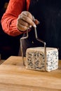 String for slicing blue cheese. Mix of cheeses on plate. Slicing dorblu, gorgonzola, roquefort. French gourmet cuisine.