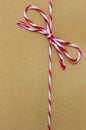 String tied in a bow, over brown paper Royalty Free Stock Photo