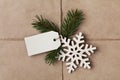 String or twine tied in a bow with tag, fir tree and wooden snowflake on kraft paper Royalty Free Stock Photo