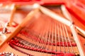 Strings close-up. Vintage red classical grand piano. Musical instrument abstract.