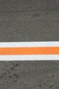 Strip of white and orange colors on a gray asphalt Royalty Free Stock Photo