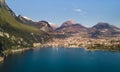 A strip of wooded and rocky mountains with a city near the shore of the lake against the blue sky Royalty Free Stock Photo