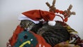 Striped adult tabby cat sleeping in a basket with red Santa Claus hat on its head during the Christmas and New Year holidays