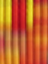 Striped background in vertical motion blured lines in red and yellow