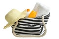 Striped beach bag, straw hat, beach towel and sunscreen Royalty Free Stock Photo