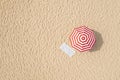 Striped beach umbrella near towel on sand, aerial view. Space for text Royalty Free Stock Photo