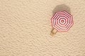 Striped beach umbrella near wooden sunbed on sandy coast, aerial view. Space for text Royalty Free Stock Photo