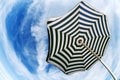 Striped beach umbrella over blue sky fish eye bottom view Royalty Free Stock Photo