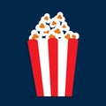 Full striped box with popcorn isolated on dark blue background Royalty Free Stock Photo