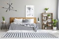 Striped carpet near bed with patterned blanket in bedroom interi