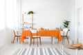Striped carpet and plants in white dining room interior