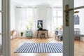 Striped carpet on wooden floor in spacious kid`s room interior with chair at desk and posters Royalty Free Stock Photo