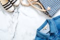 Striped casual clothing on marine style, flat lay composition on marble background. Lifestyle of beauty blogger, millennial tender