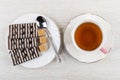 Striped chocolate cookies, teaspoon, sugar cubes in plate, tea