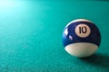 Striped color blue and white billiard ball with number 10 on green table background Royalty Free Stock Photo